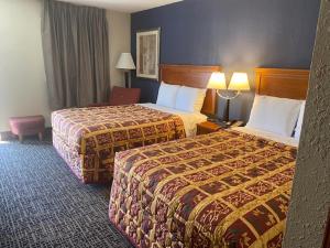 een hotelkamer met twee bedden en een stoel bij Andy Griffith Parkway Inn in Mount Airy +45 foto's