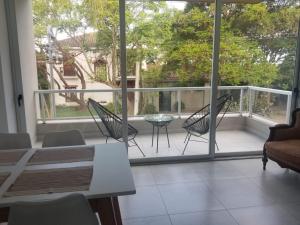 a balcony with chairs and a table and a large window at Ayres de Nieva 2 in San Salvador de Jujuy