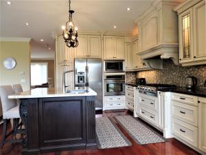 una gran cocina con armarios blancos y una isla negra en iResidence in Toronto - LUX 3 Bedroom Vacation Home, en Toronto