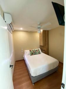 um quarto com uma cama num pequeno quarto em Apartaestudios - Casa Tamarindo em Aracataca