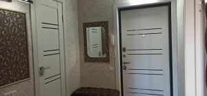 ニジネカムスクにあるApartment on Stroiteleyの白いドア2つと鏡が備わる部屋