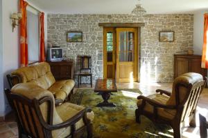 sala de estar con sofá, sillas y pared de piedra en Semi-detached house, Bénodet, en Bénodet