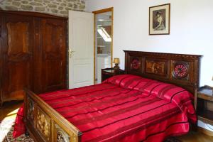 a bedroom with a wooden bed with a red blanket at Semi-detached house, Bénodet in Bénodet