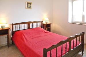 a bedroom with a wooden bed with a red blanket at Stone cottage with shared pool, Chambonas in Chambonas