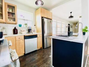 a kitchen with a blue and white refrigerator and cabinets at La Mariposa San Antonio - New! 5 min to Downtown! in San Antonio