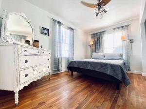 a bedroom with a white bed and a dresser at La Mariposa San Antonio - New! 5 min to Downtown! in San Antonio