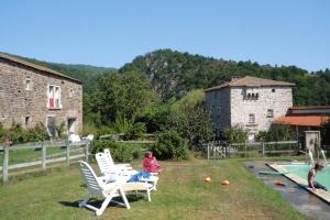 a woman sitting in a yard next to a pool at Holiday flat, Retournac in Retournac