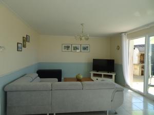 een woonkamer met een bank en een tv bij Holiday home, Moëlan sur Mer in Moëlan-sur-Mer