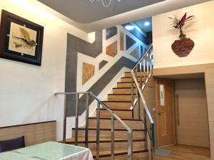 una escalera en una casa con un mural en la pared en Runners' House Taitung, en Changbin