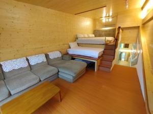 a living room with a couch and a bed at Runners' House Taitung in Changbin