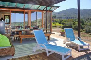 un patio con 2 sedie blu e un tavolo in legno di Holiday home Biocasa Fabiana, Portoferraio Magazzini a SantʼAnna