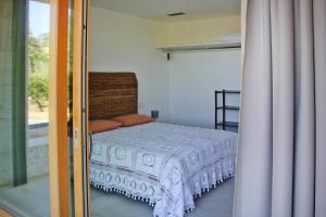 una camera con letto e porta scorrevole in vetro di Holiday home Biocasa Fabiana, Portoferraio Magazzini a SantʼAnna