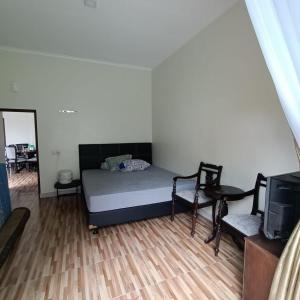 a small bedroom with a bed and a tv at Villa Names2 Gunung Bunder in Gunungpicung