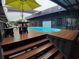 a deck with a swimming pool and an umbrella at Hotel Bonito Motobox - HOTEL CONTAINER in Bonito