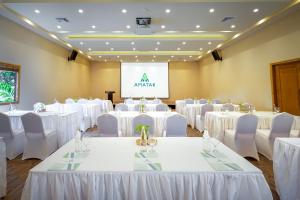 einen Konferenzraum mit weißen Tischen und Stühlen und einem Bildschirm in der Unterkunft Amatak Boutique Hotel in Siem Reap + 158 Fotos