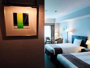 倉敷市にある倉敷ロイヤルアートホテルのベッド2台が備わる客室で、壁には絵画が飾られています。
