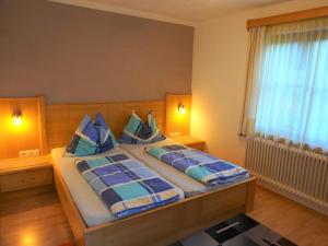 a bedroom with a large bed with blue pillows at Apartment house Sylvia, Flachau in Flachau