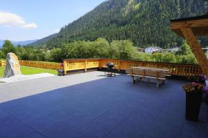 a wooden deck with a picnic table and a bench at Apartment house Sylvia, Flachau in Flachau