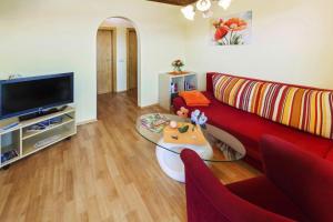 a living room with a red couch and a tv at Bungalow in St Kanzian am Klopeler See with a terrace in Unternarrach