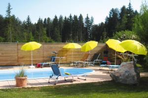 una piscina con quattro ombrelloni e sedie gialle e un gruppo di tavoli di Adults only apartment with pool a Wasserhofen