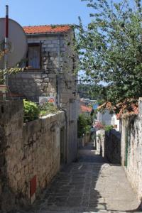 an alley in an old stone building with a tree at Apartment Milu - 80m from sea in Cavtat