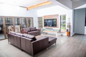 uma sala de estar com dois sofás e uma televisão em Boruundi Private Lodge & Campsite em Bokaa