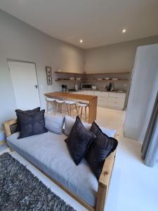 Una sala de estar con un sofá y una cocina. en Still Bay East Beach Apartment, en Stilbaai