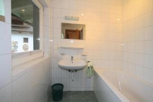 biała łazienka z umywalką i wanną w obiekcie holiday home, Itter w mieście Itter +4 zdjęcia