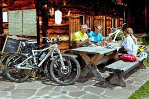 a group of people sitting at a picnic table with a bike at Holiday flat B rlerhof XXL K nigsleiten in Königsleiten