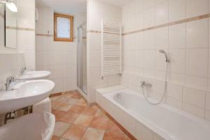 a white bathroom with a tub and a sink and a bath tub at Holiday flat B rlerhof XXL K nigsleiten in Königsleiten