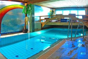 una gran piscina cubierta con un arco iris. en Landhaus Salzburg, Dienten, en Dienten am Hochkönig