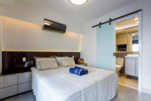 1 dormitorio con 1 cama blanca grande con almohadas azules en AP Premium 208 Centro de SP - Localização Privilegiada !, en São Paulo