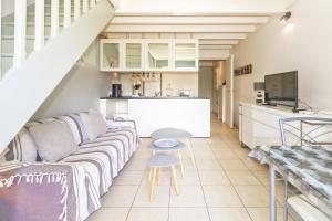 ein Wohnzimmer mit Sofa und Tisch in der Unterkunft Purple - Duplex cosy en plein cœur de l'Hermitage, proche du lagon in L'Ermitage-Les-Bains