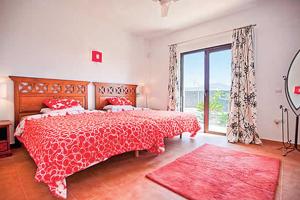 プラヤ・ブランカにあるRaquelのベッドルーム1室(赤いベッドカバー、窓付)