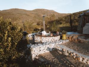 a backyard with a stone fire pit in a yard at Southern Yurts in Botrivier