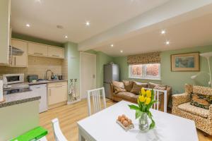 a kitchen and living room with a table and a couch at Rectory Cottage in Abergavenny