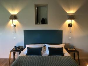 a bedroom with a bed with a blue headboard and two tables at La Grange Saint Martin in Fontaine-le-Port