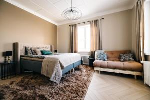 a bedroom with a bed and a couch at Lilla Rantala, luksusmajoitus keskustassa in Seinäjoki