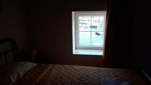 a bedroom with a window with a boat in the water at Guest House Provišta in Veli Iž