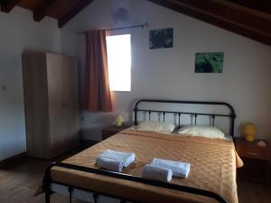 ein Schlafzimmer mit einem Bett mit zwei Handtüchern darauf in der Unterkunft Guest House Provišta in Veli Iž