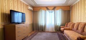 sala de estar con sofá y TV de pantalla plana en Apartments Tiraspol en Tiraspol