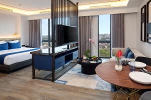 a hotel room with a king bed and a living room at Hotel Aruss Semarang in Semarang