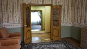 Habitación con puerta, silla y espejo en Apartments Tiraspol en Tiraspol