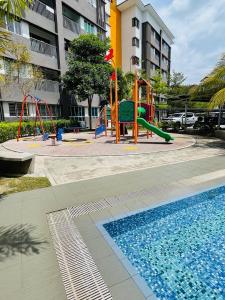 a playground with a slide next to a swimming pool at Wallaway2stay Kiara Nilai Apartment 3 Bedroom in Nilai