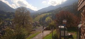 a village in a valley with mountains in the background at Le charmant somme - vue et terrasse privative in Saint-Pierre-dʼEntremont