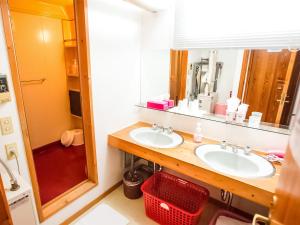 a bathroom with two sinks and a mirror at Rusutsu Lodges Pension Lilla Huset in Rusutsu +46 photos