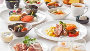 a table with plates of food on it at Premier Hotel CABIN PRESIDENT Osaka in Osaka