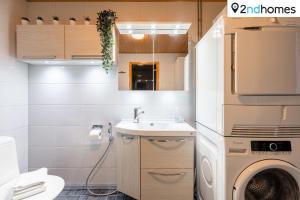 ein Badezimmer mit Waschmaschine und Waschbecken in der Unterkunft Homelike 1BR Apartment with Sauna, Balcony & Free Parking in Tampere + 10 Fotos