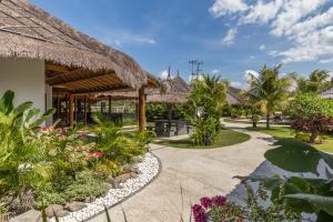 een pad door een resort met bloemen en planten bij Emocean Beach Boutique Dive Resort in Amed