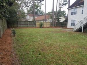 a yard with a fence and a house at Lovely two-story house with spacious backyard in Summerville